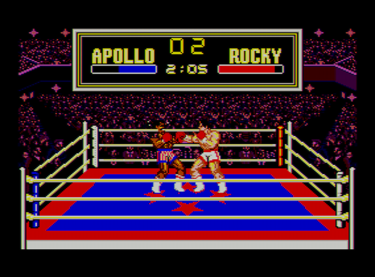 Captura de Rocky. Vemos a dos luchadores sobre un ring que parece estar en el centro de un gran estadio. A la derecha Rocky y a la izquierda Apollo. El luchador de la derecha lanza un puño hacia el de la izquierda. En la parte superior se ve un marcador con el tiempo y la vida de los luchadores.